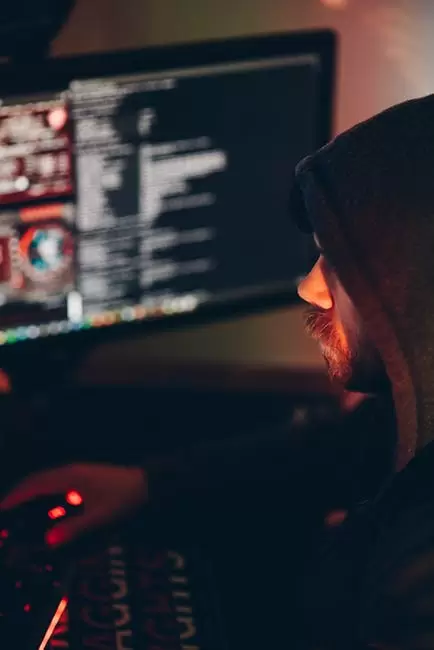 Hacker Masculino De Cultivo Viendo La Computadora De Escritorio En La Oscuridad