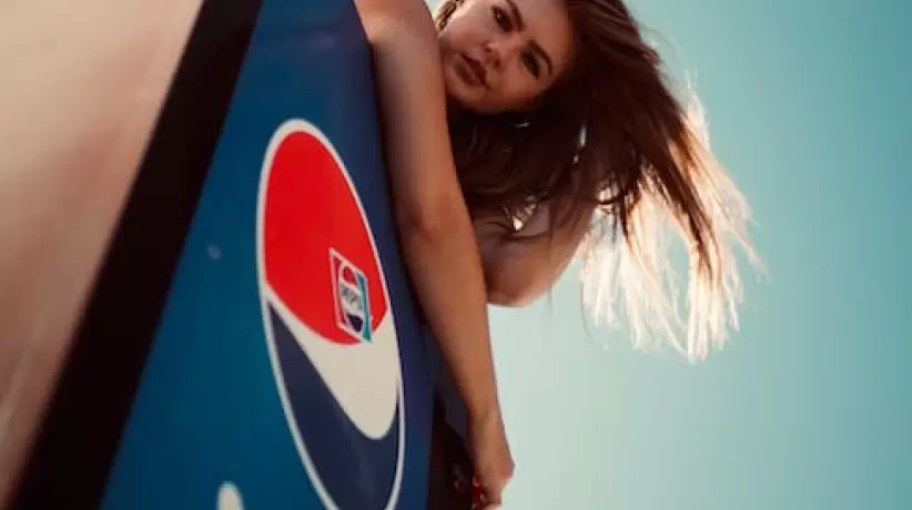 Foto De ngulo Bajo De Mujer En La Parte Superior De La Nevera Pepsi Posando