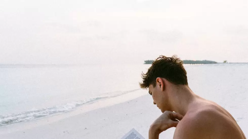 Libro De Lectura De Hombre En Topless Mientras Est Sentado En La Playa