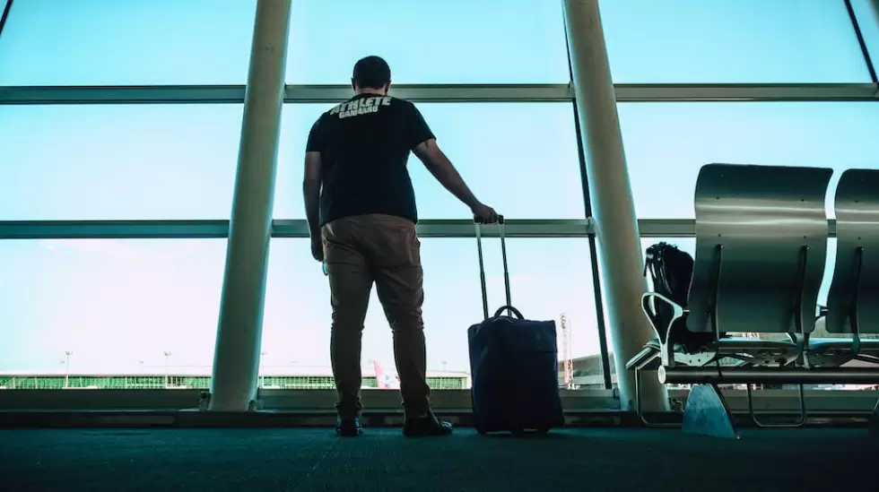 Hombre Sujetando La Bolsa De Equipaje