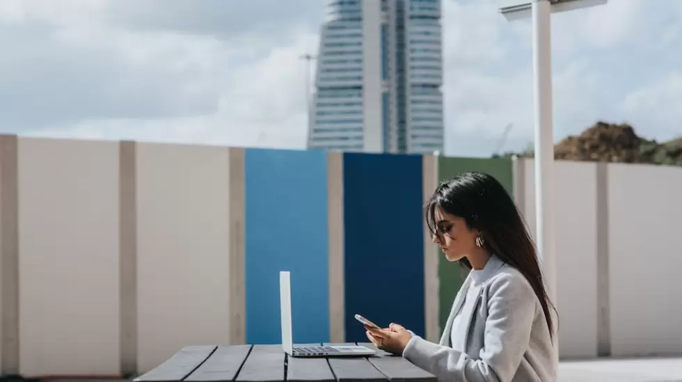 Ejecutivo Femenino tnico Viendo Smartphone En La Mesa Con El Porttil Al Aire L