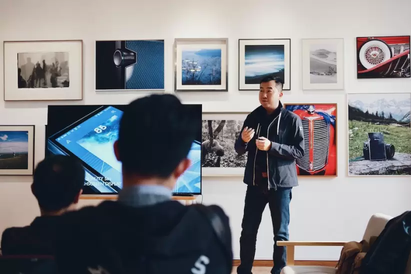 Hombre Al Lado De La Televisin De Pantalla Plana Con Fondo De Fotos