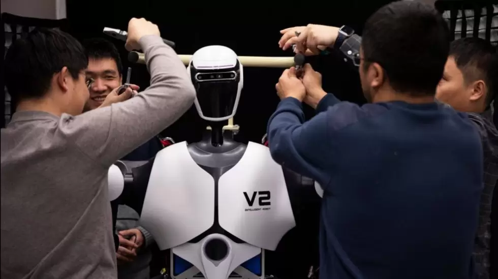 Alumnos de la Universidad de Tsinghua trabajando sobre un robot en el laboratori