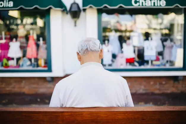Hombre De Camisa Blanca Sentado En Un Banco De Madera Marrón. (Foto: Pexels)