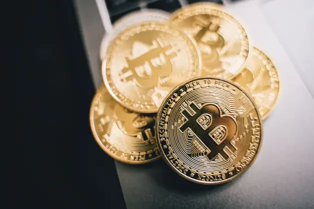 Primer plano de monedas de Bitcoin doradas sobre un teclado de laptop, simbolizando la inversión en criptomonedas. (Foto: Pexels)