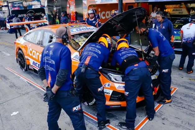 Los mecánicos de carreras trabajan con entusiasmo en un coche deportivo en la zona de pits durante la competición. (Foto: Pexels)