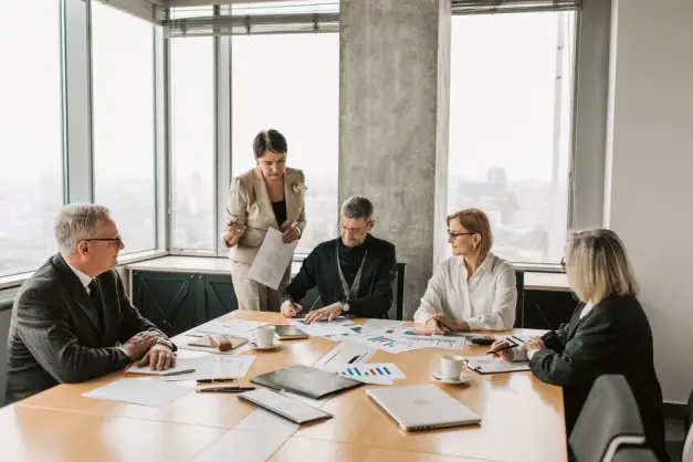 Profesionales discutiendo documentos durante una reunión de negocios en un ambiente de oficina moderno. (Foto: Pexels)