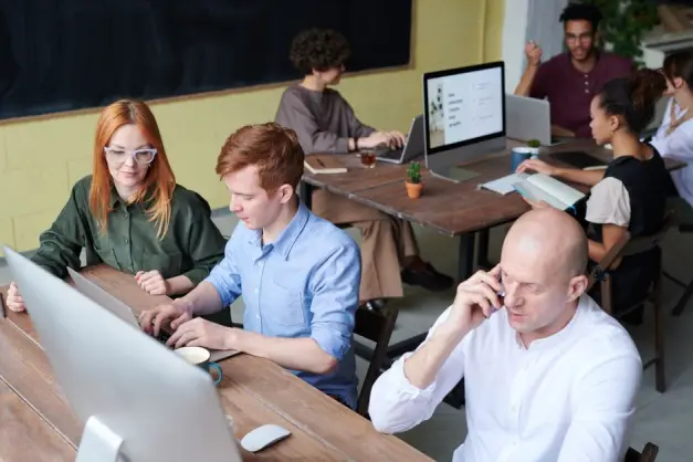 Un equipo ocupado de profesionales colaborando en un espacio de oficina moderno durante el día. (Foto: Pexels)