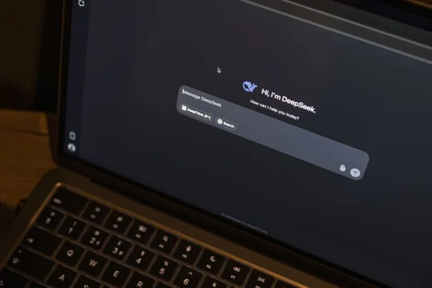Una computadora portátil sobre una mesa de madera muestra una interfaz de chat de inteligencia artificial, con el chatbot DeepSeek en acción.