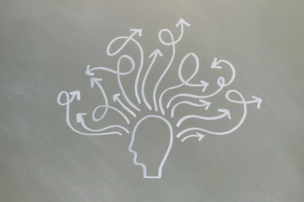 Dibujo conceptual a tiza que ilustra los desafíos de la salud mental con flechas que representan pensamientos.