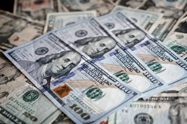 Primer plano de varios billetes de dólares estadounidenses que resaltan las finanzas y la economía.