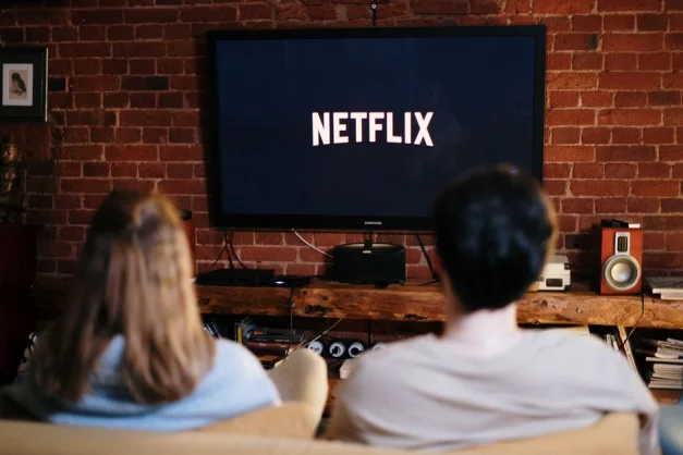 Una pareja relajándose y viendo Netflix en un acogedor salón.