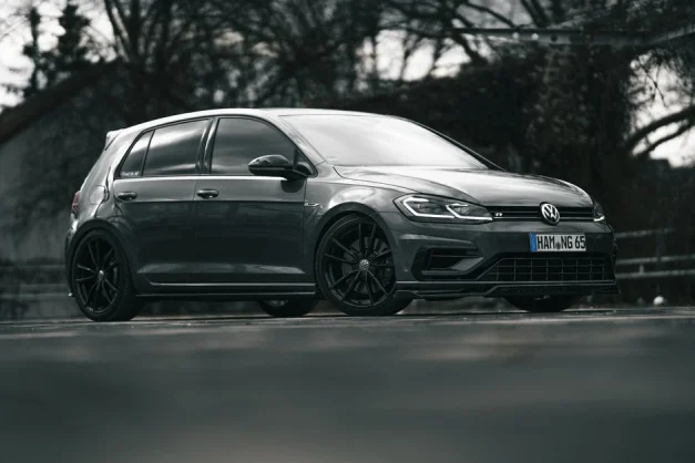 Un elegante Volkswagen Golf R negro aparcado en la carretera, mostrando su diseño estiloso.